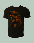 Black short sleeve t-shirt with orange cursive letters that says The Next Waltz. The words are coming out of an orange vintage tape player at the bottom of the shirt.